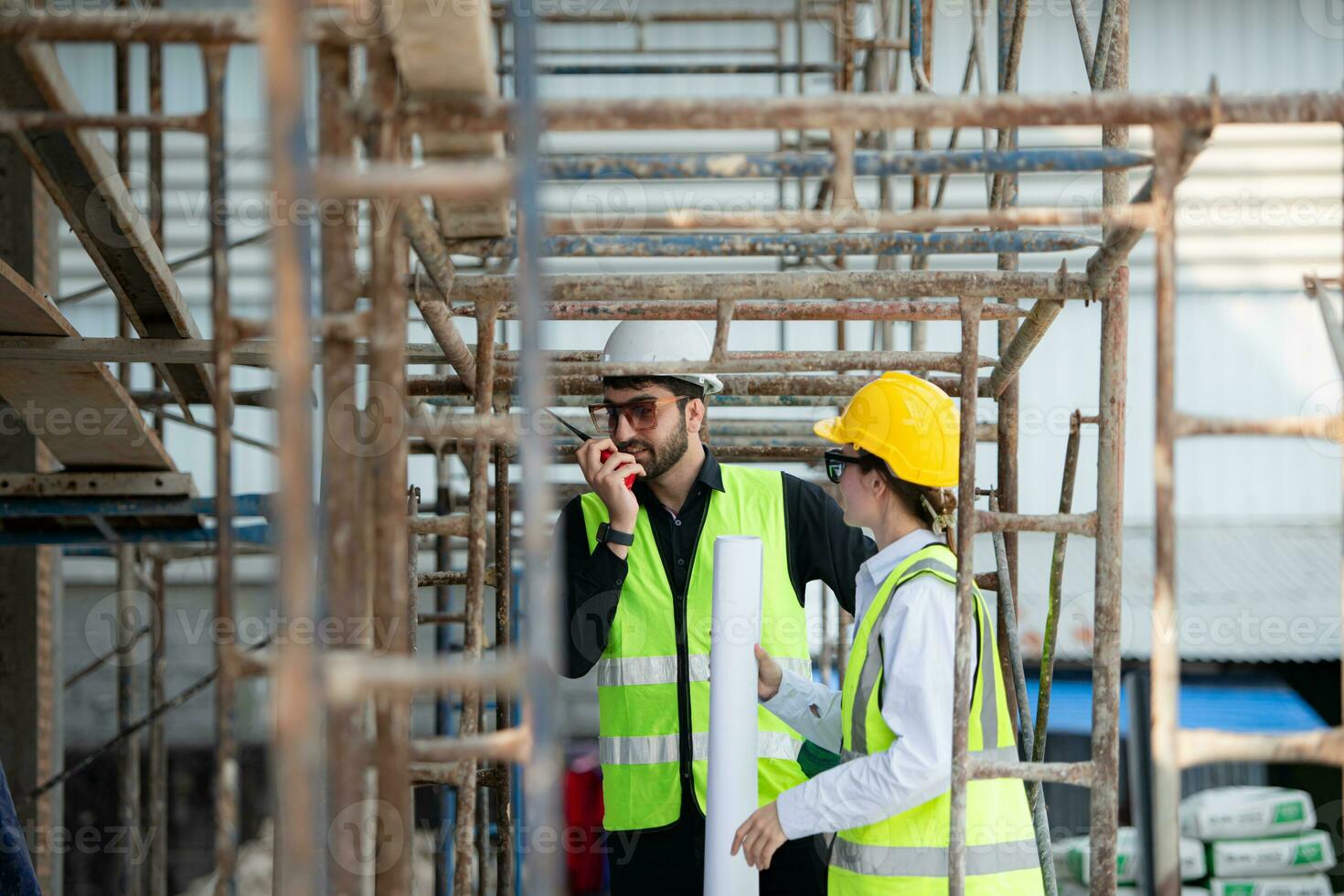 Engineer and architect working on the construction site, double-checking plans and process. photo
