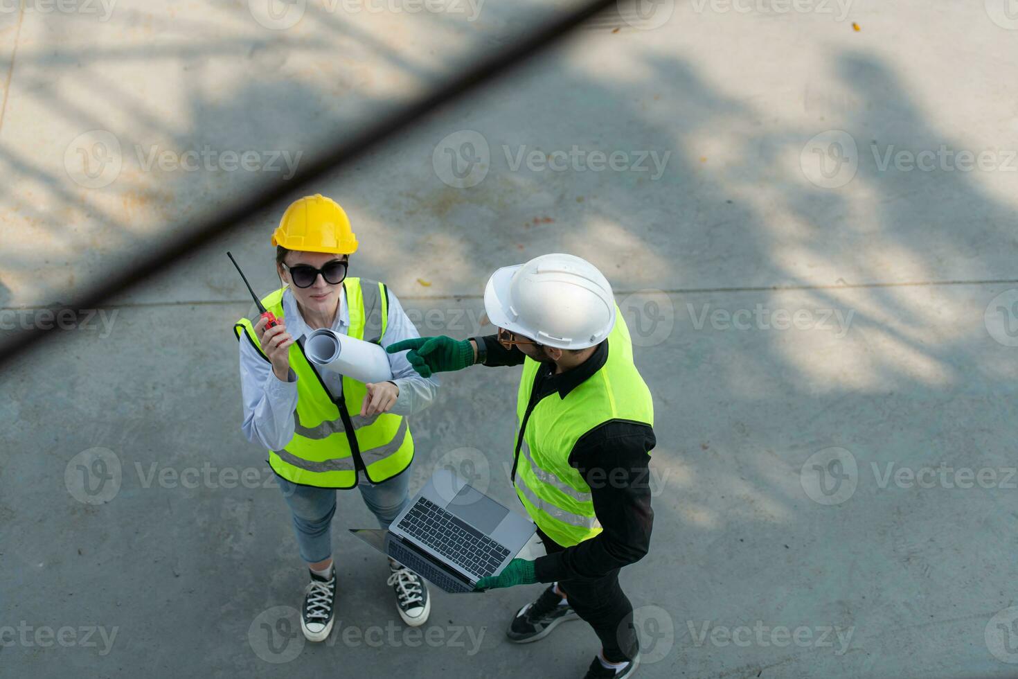 Overhead view on a building site, an engineer and architect are discussing on a laptop. photo
