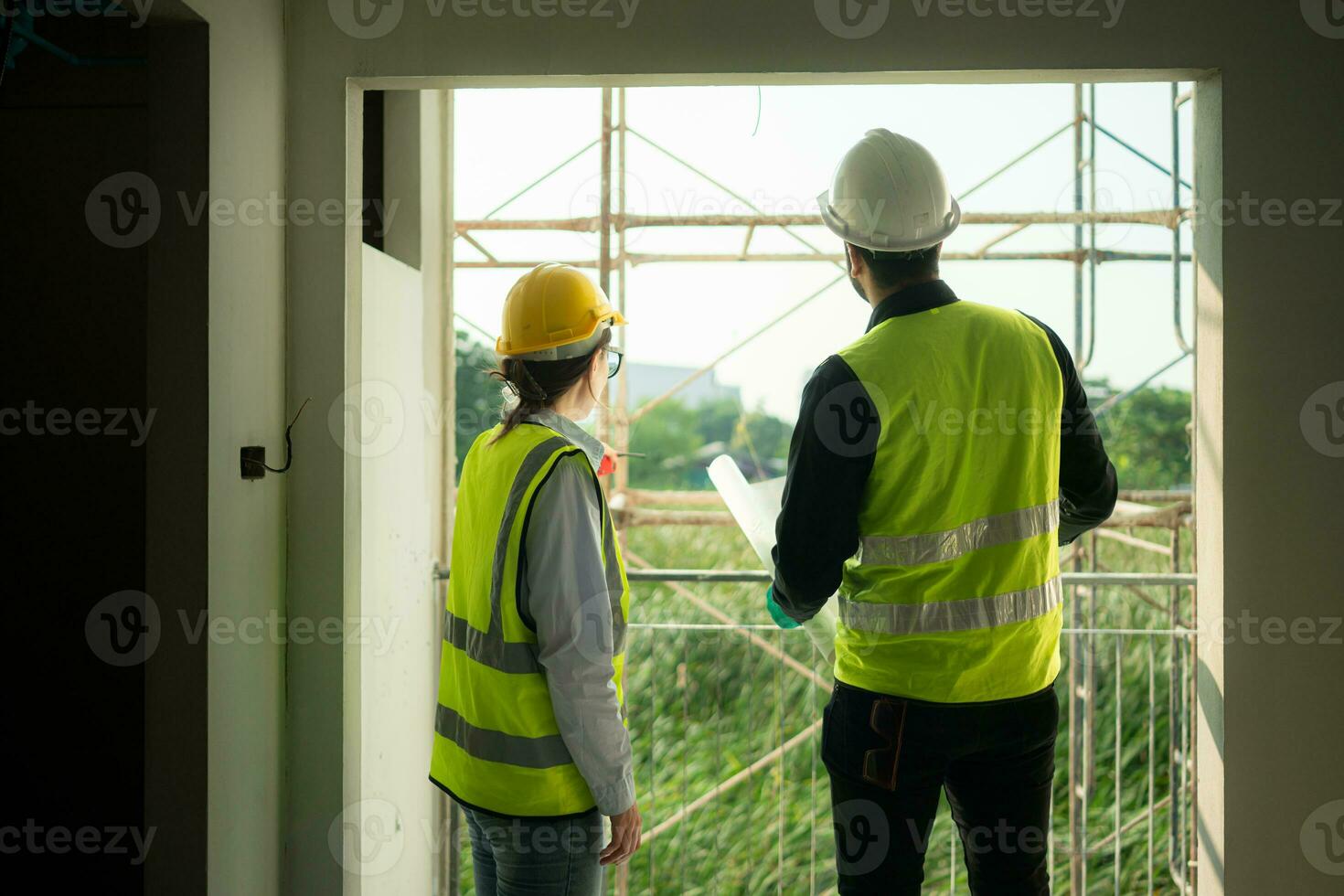 Engineer and architect working on the construction site, double-checking plans and process. photo