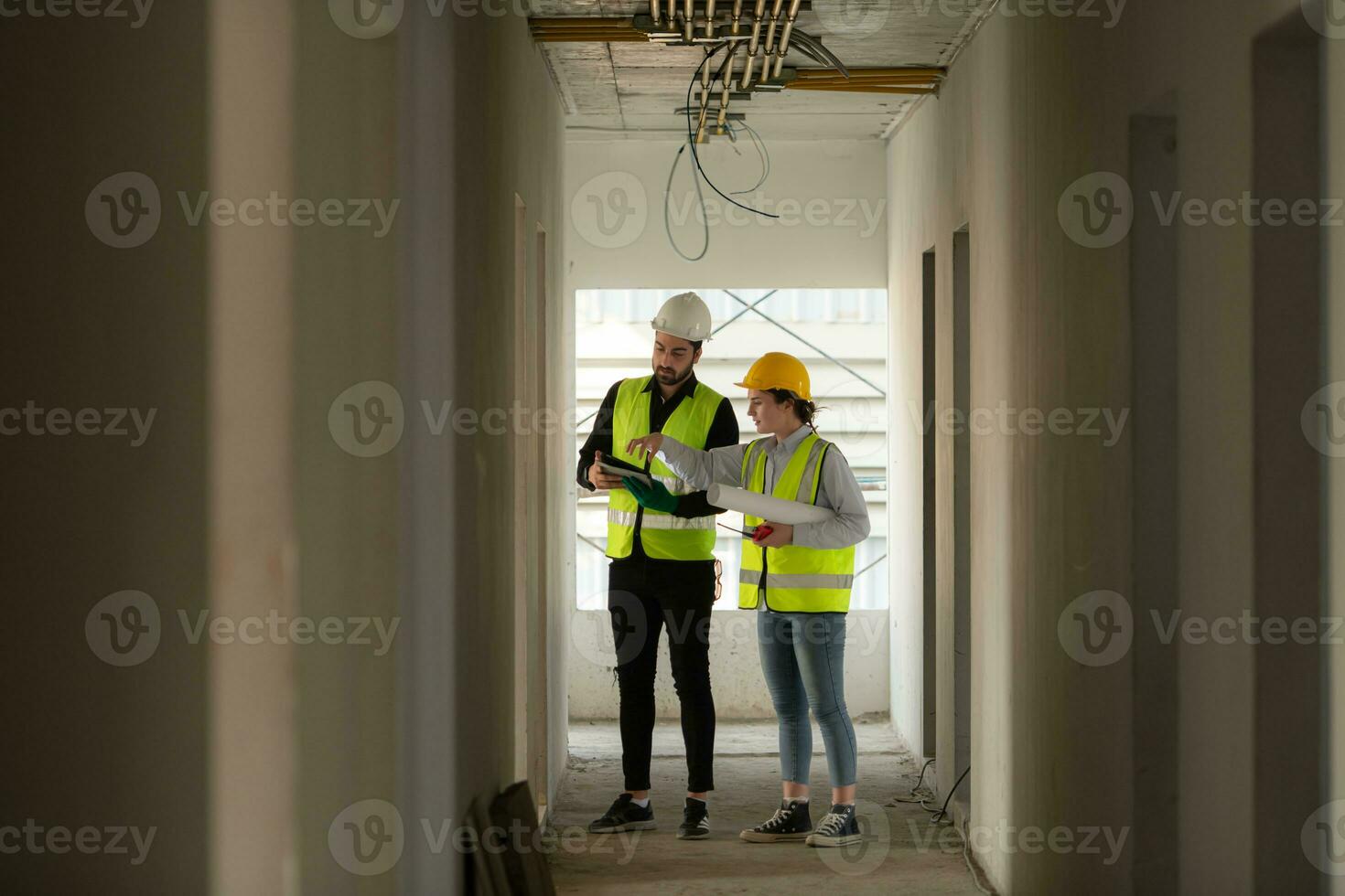 Engineer and architect working on the construction site, double-checking plans and process. photo