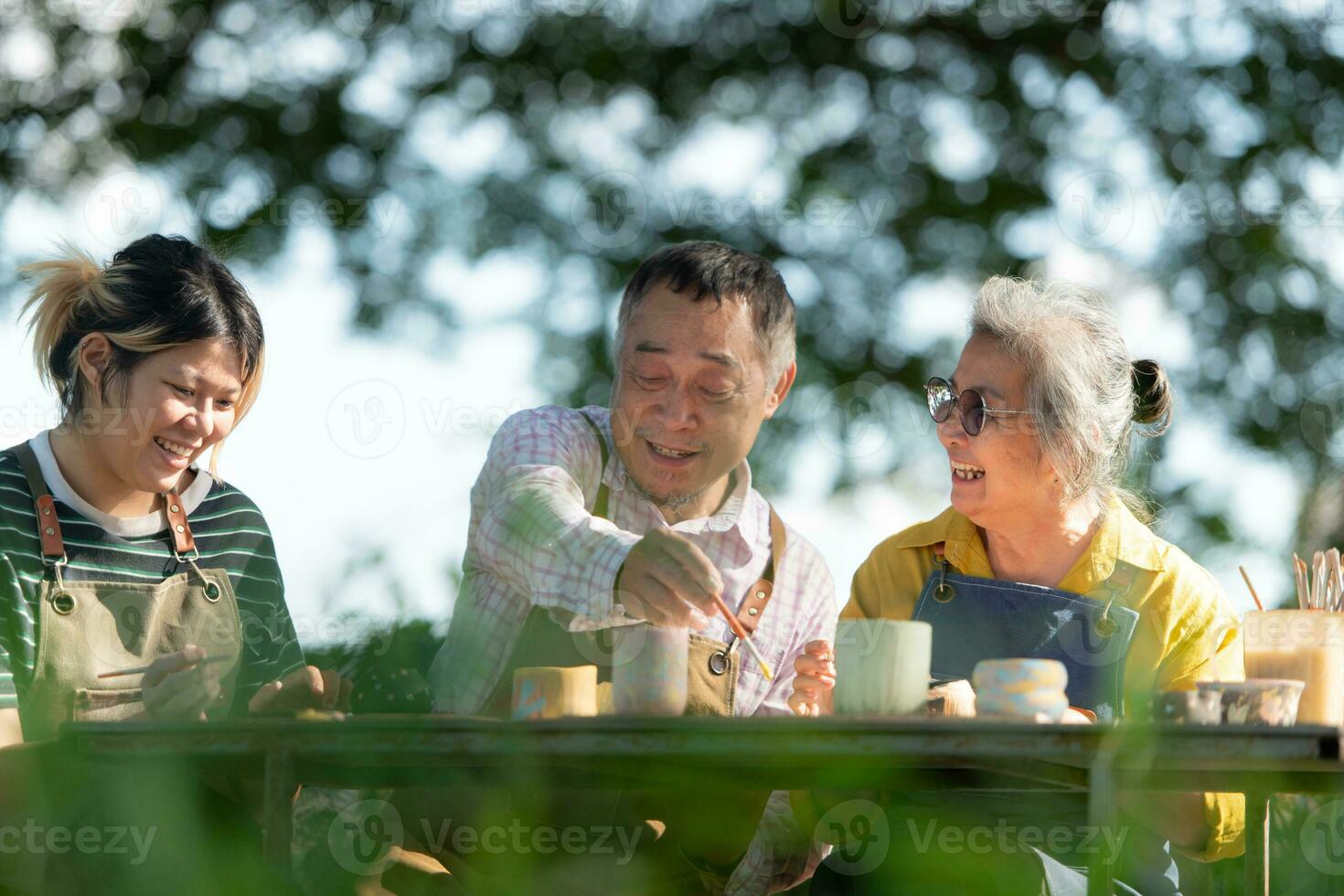 In the pottery workshop, an Asian retired couple is engaged in pottery making and clay painting activities. photo