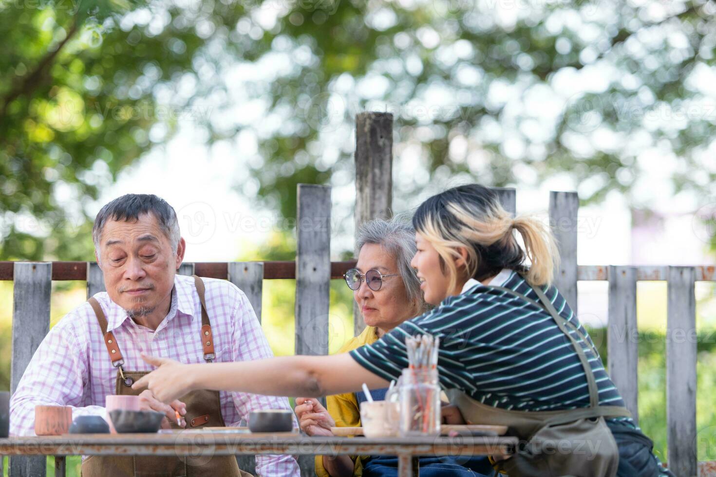 In the pottery workshop, an Asian retired couple is engaged in pottery making and clay painting activities. photo