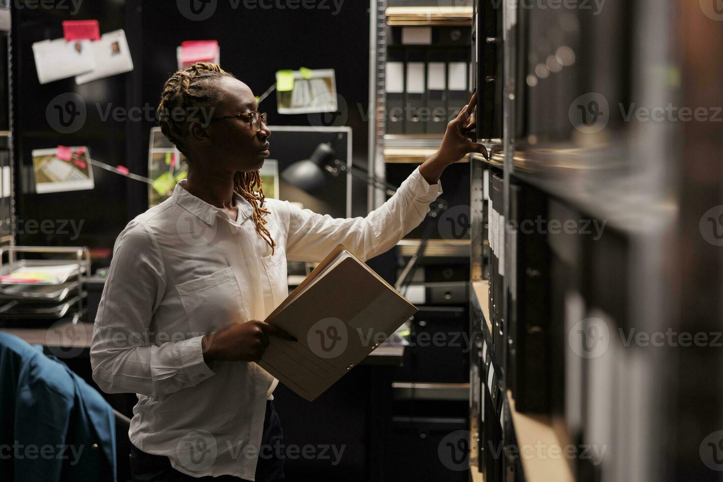 Police investigator searching crime case file in records storage. Law enforcement detective taking forensic report from rack to analyze criminal investigation information photo