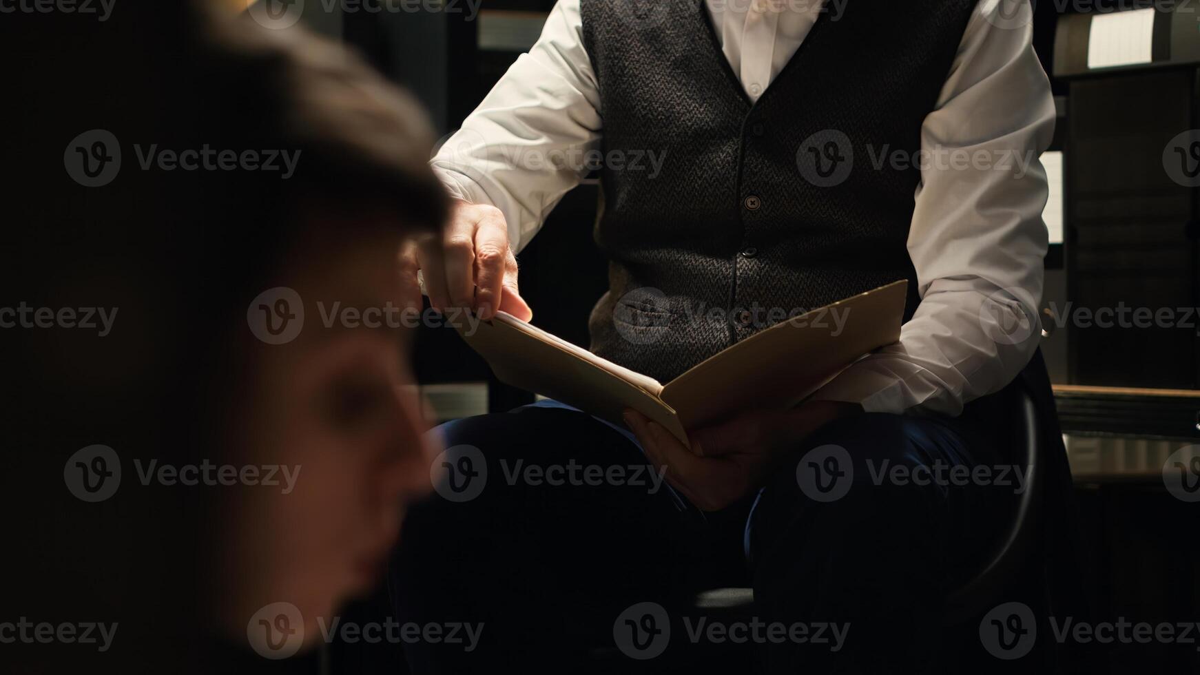 Law agents team carrying out meticulous detective work with confidential records and criminal investigation tools. Two police officers verifying forensic evidence in case file. Handheld shot. photo