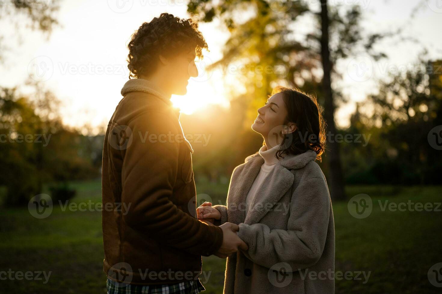 retrato de contento amoroso Pareja en parque en puesta de sol. Pareja en silueta mirando a cada otro. foto