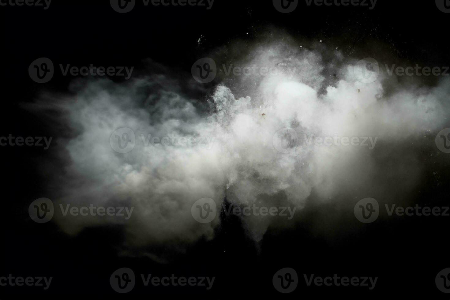 White powder explosion.Freeze motion of white dust particles on black background. photo