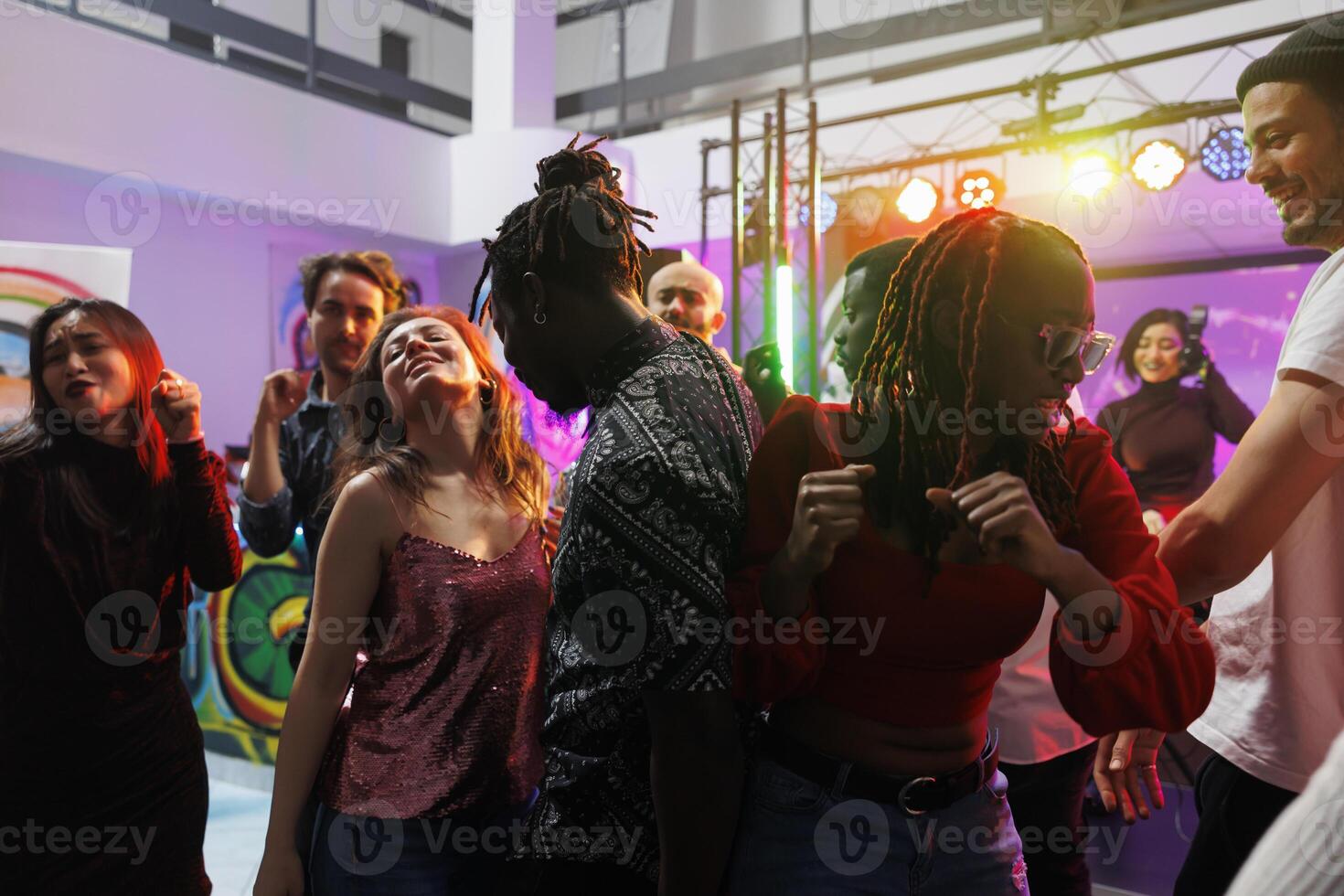 contento amigos grupo bailando y teniendo divertido en concurrido pista de baile mientras asistiendo reunión en Club nocturno. alegre diverso personas saltando y Moviente a música late en club foto