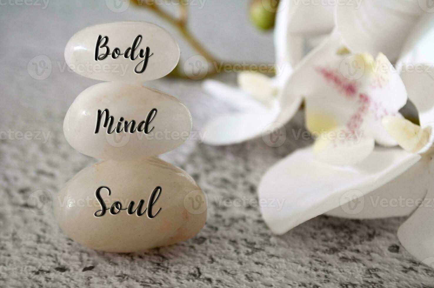 Body, Mind and Soul text engraved on white zen stones Meditation and spa concept photo