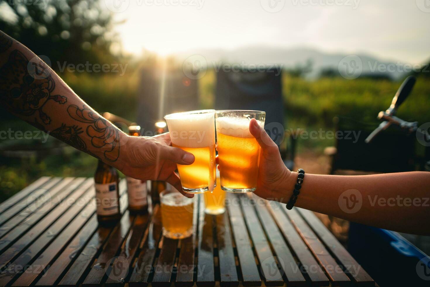 cerveza en el mesa y cámping fiesta, manos tostado en cerveza, foto