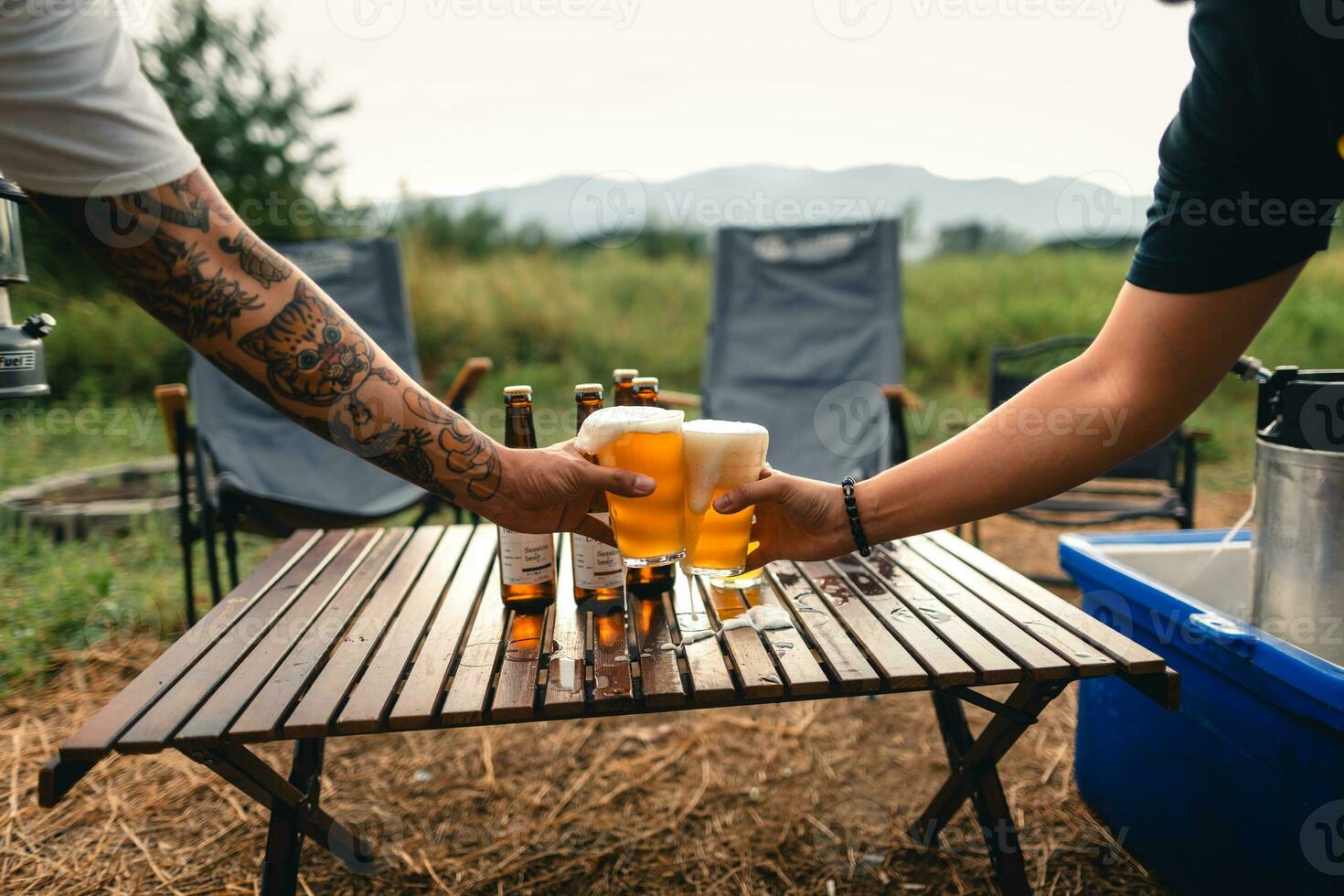 Beer on the table and camping party,hands toasting in beer, photo