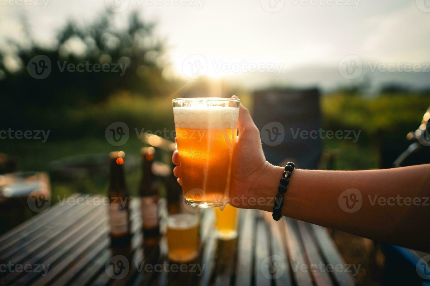 Beer on the table and camping party,hands toasting in beer, photo