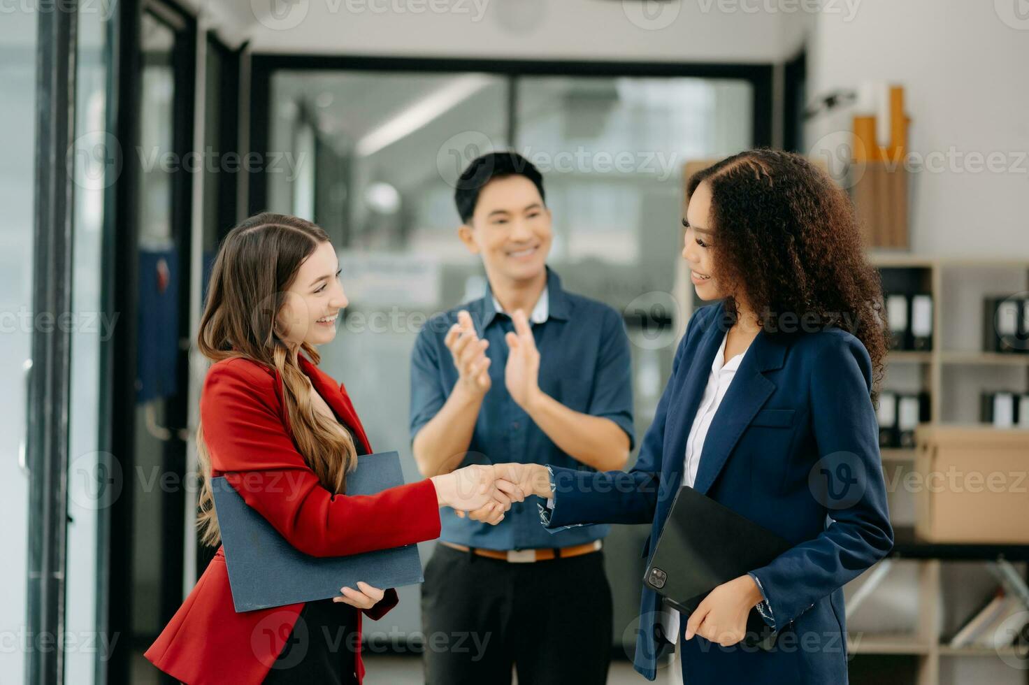 negocio personas sacudida manos durante un reunión. dos contento joven empresarios y mujer foto