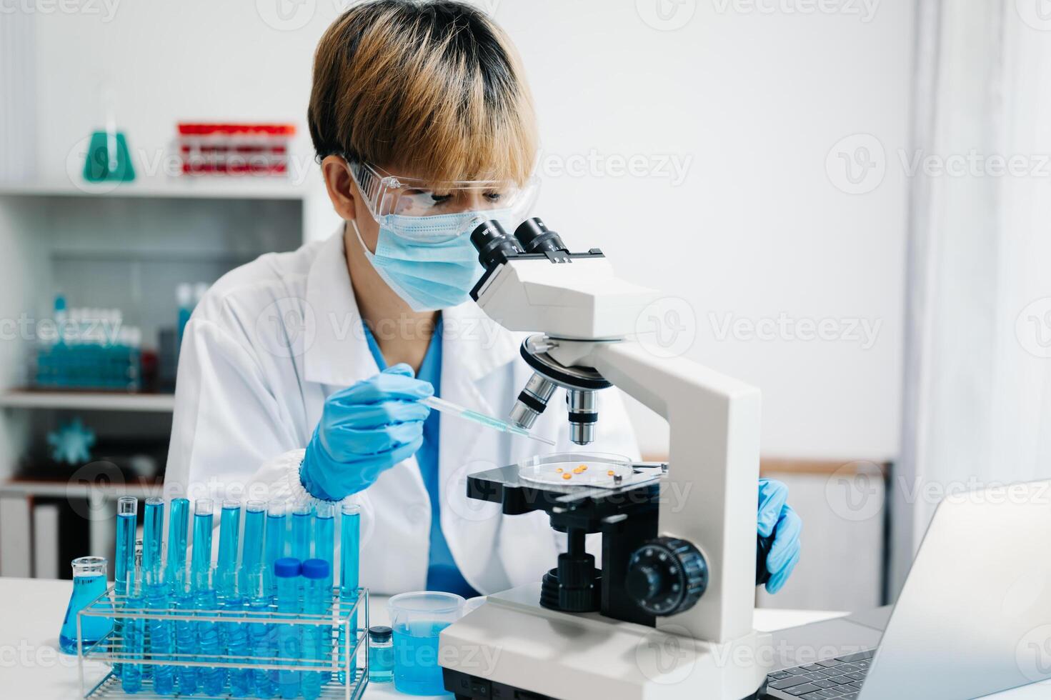 female scientist working with micro pipettes analyzing biochemical ...
