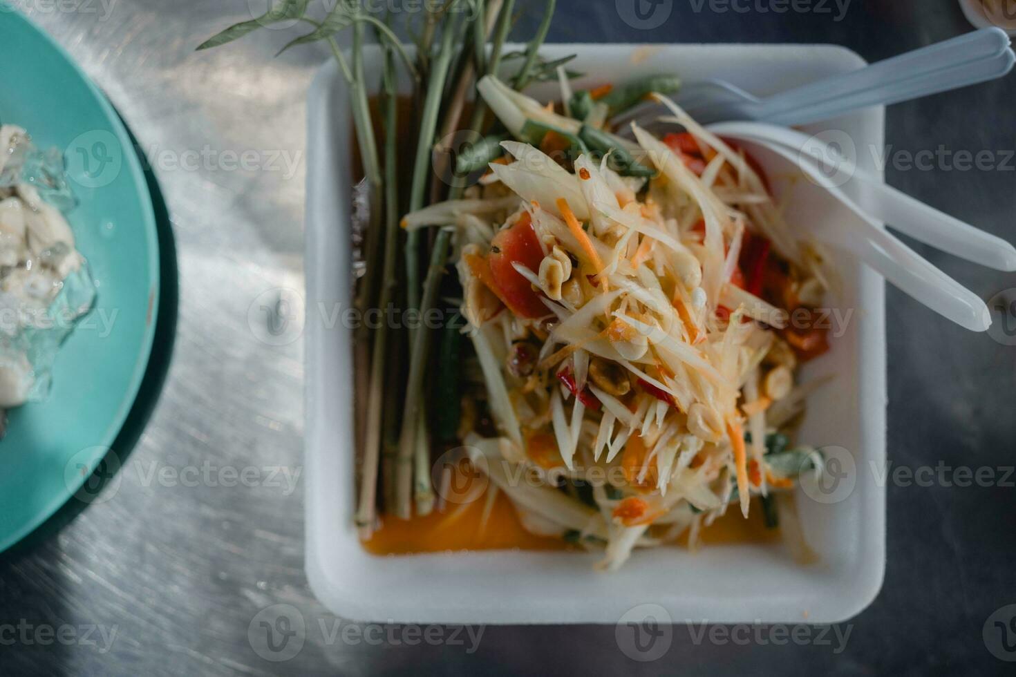 Spicy papaya salad yummy or somtum is a Thai foods serve on foam tray photo