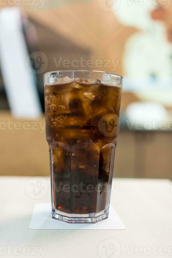 A glass of cold soft drink with ice photo