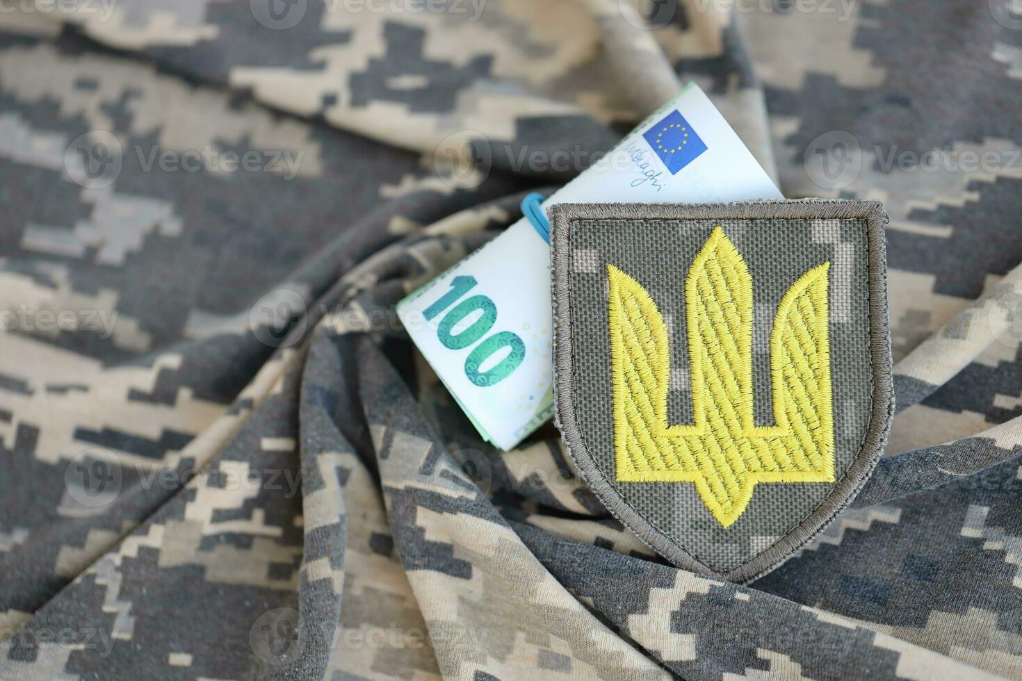 Ukrainian army symbol and bunch of euro bills on military uniform. Payments to soldiers of the Ukrainian army from European union, salaries to the military. War support photo