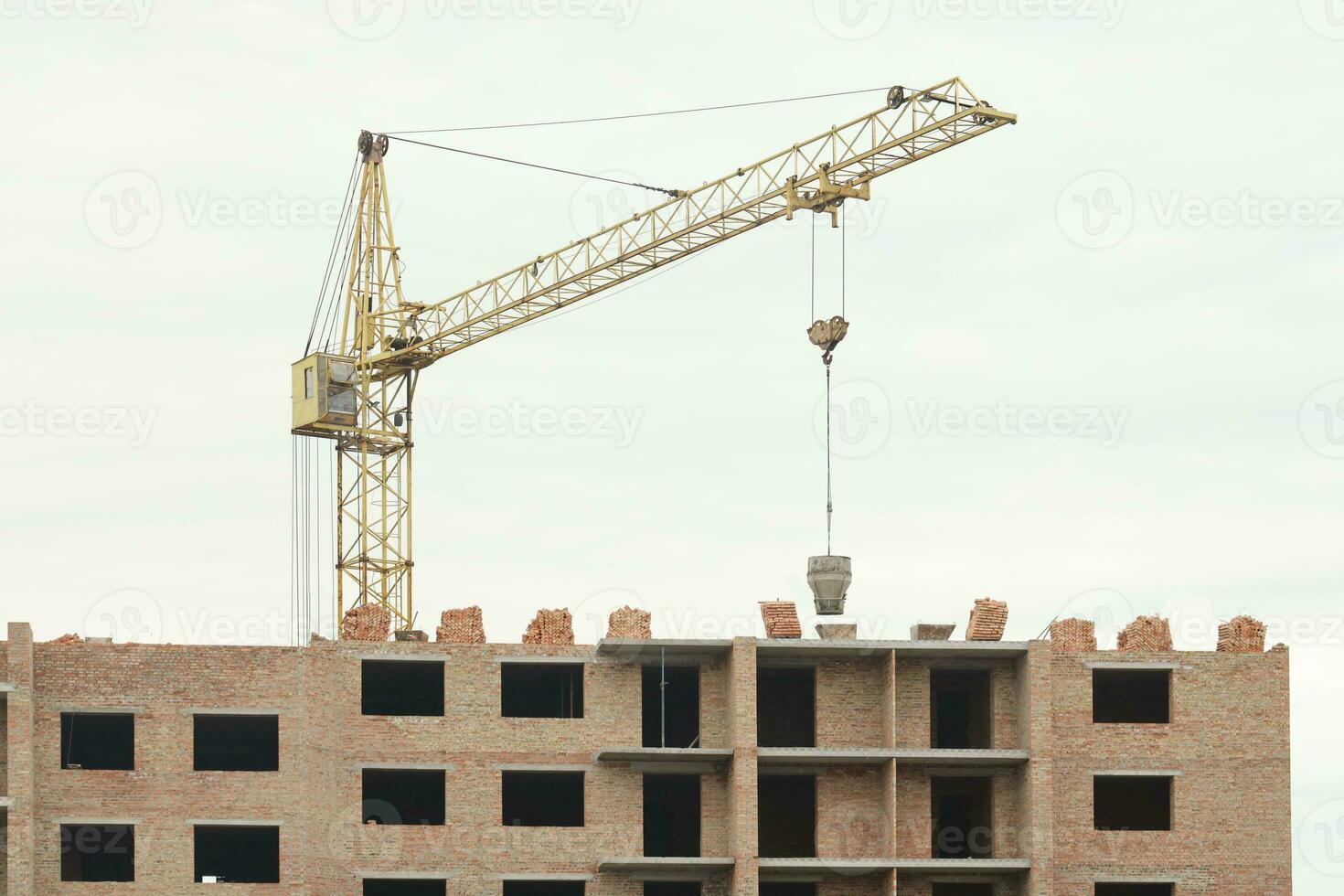 View of a large construction site with buildings under construction and multi-storey residential homes. Tower cranes in action on blue sky background. Housing renovation concept photo