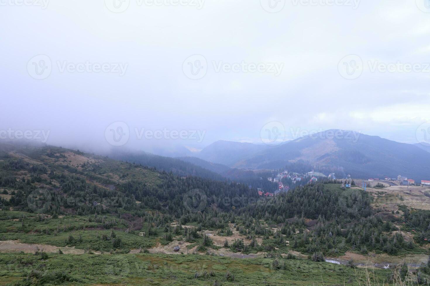 Morning view from the Dragobrat mountain peaks in Carpathian mountains, Ukraine. Cloudy and foggy landscape around Drahobrat Peaks photo