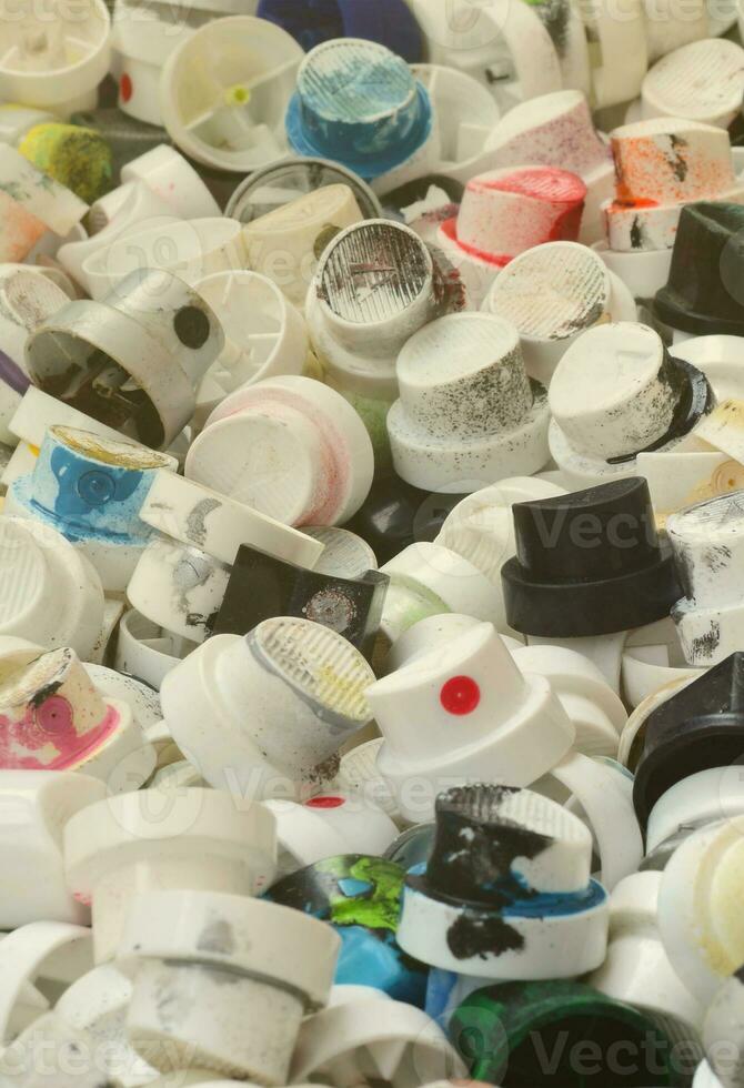 A pattern of many used and soiled nozzles from spray cans with aerosol paint. Background texture of the street art of drawing graffiti on the walls photo