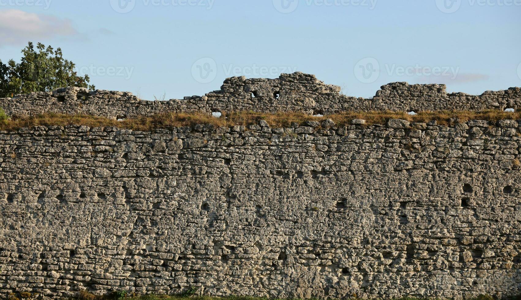 Very old brick stone wall of castle or fortress of 18th century. Full frame wall with obsolete dirty and cracked bricks photo