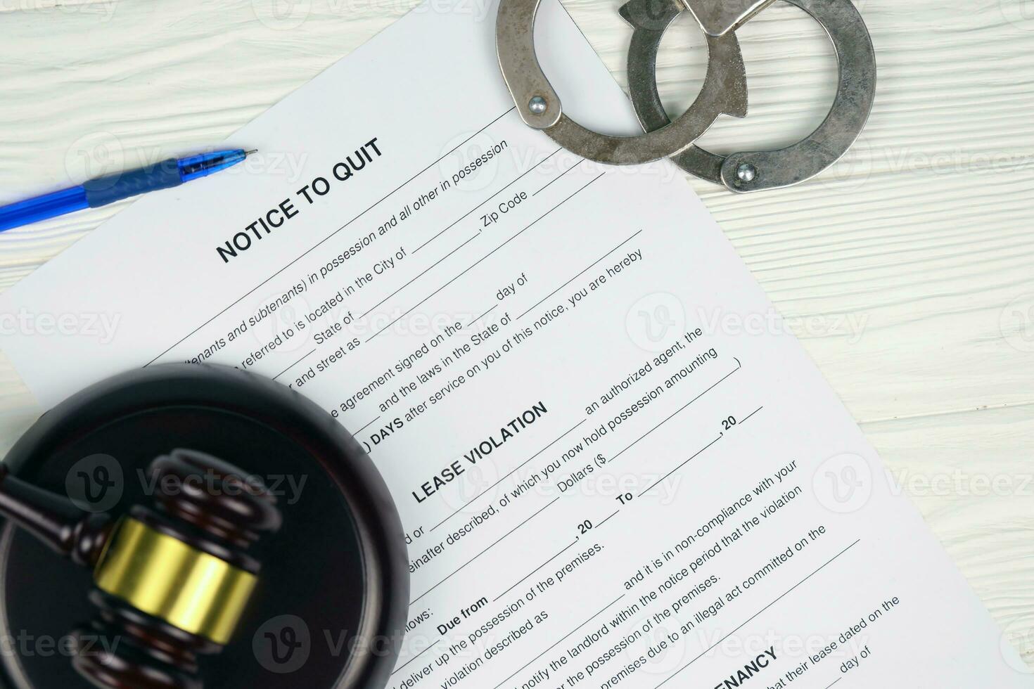 Notice to quit or eviction notice blank document paper ready to fill with handcuffs and judge mallet on table photo