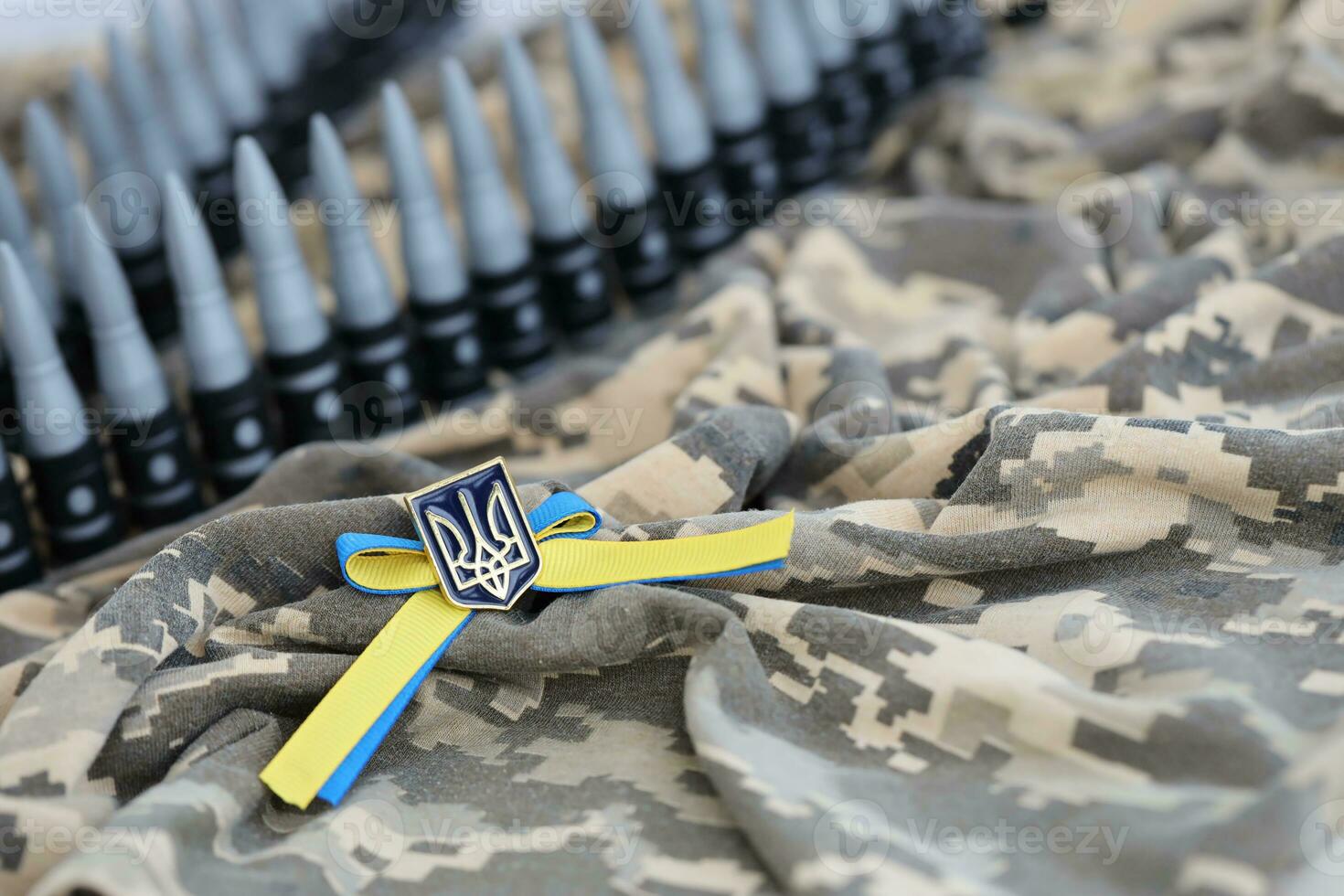 Ukrainian symbol and a machine gun belt on the camouflage uniform of a Ukrainian soldier. The Concept of war in Ukraine, patriotism and protecting your country from occupiers photo