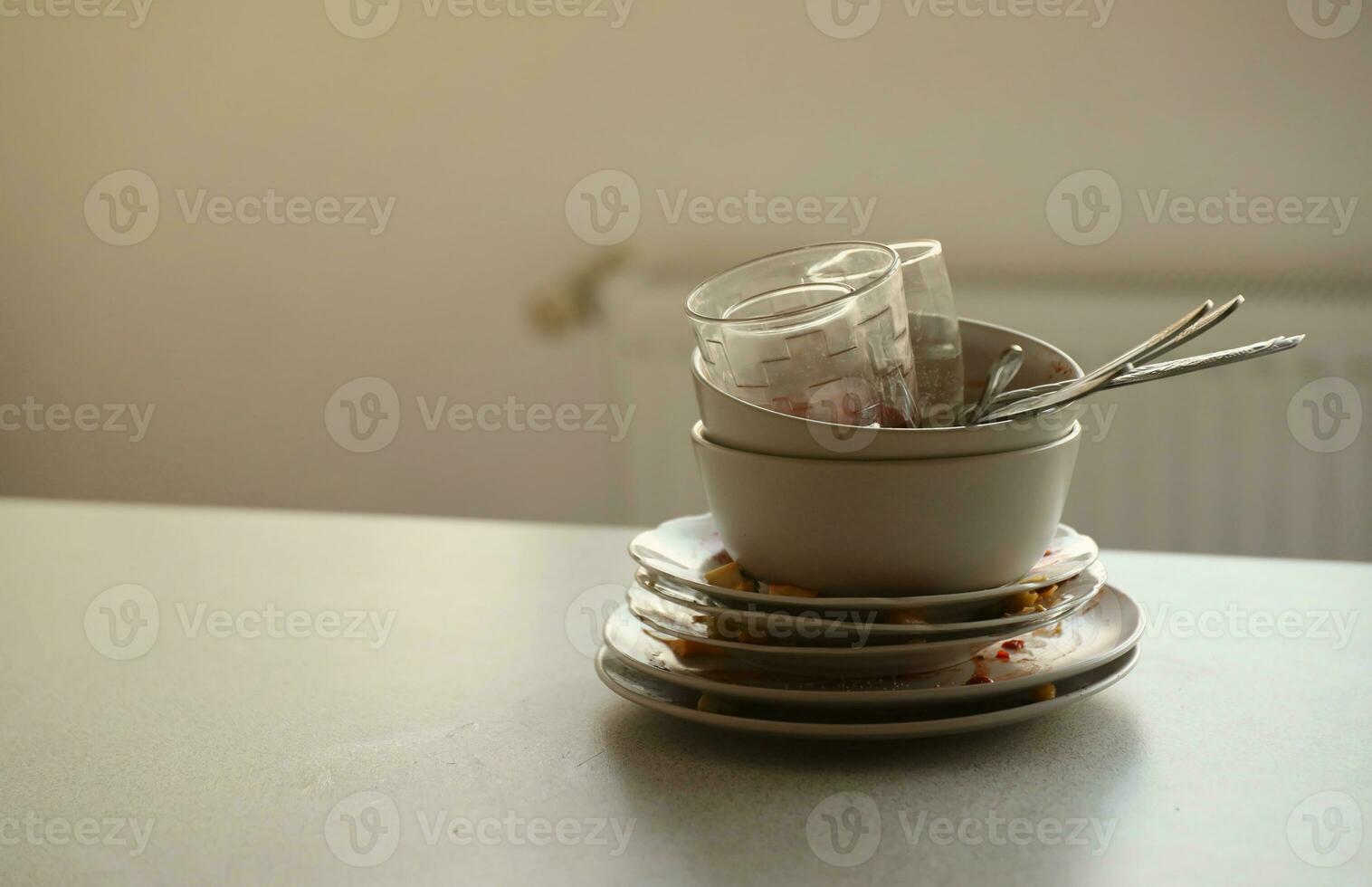 Stack of dirty dishes with food leftovers on the table after meal. Banquet ending concept. Unwashed dishes photo