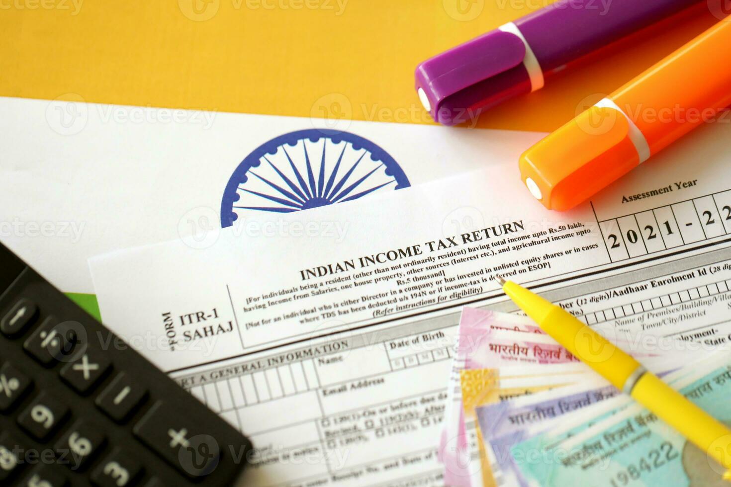 Indian income tax return blank form with pen and indian rupees bills photo