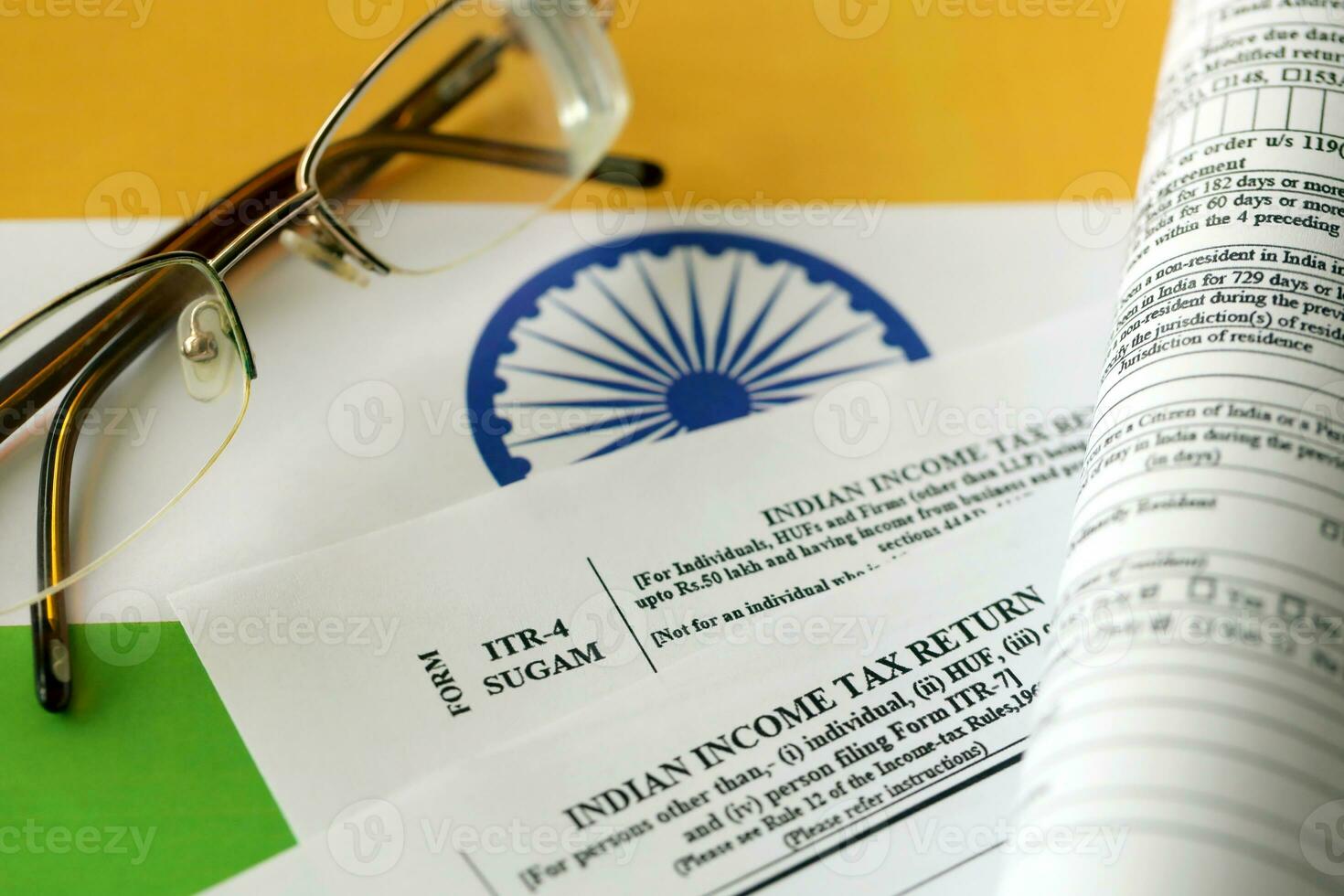 Indian income tax return blank form with pen and indian rupees bills photo