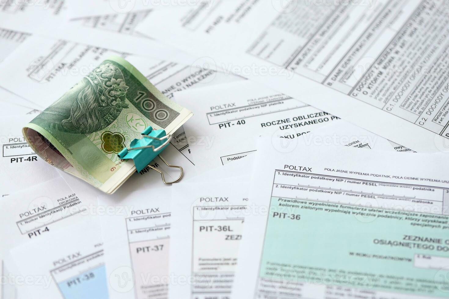 Polish zloty money on big amount of polish tax forms close up. Accounting, bureaucracy and taxpayers routine photo