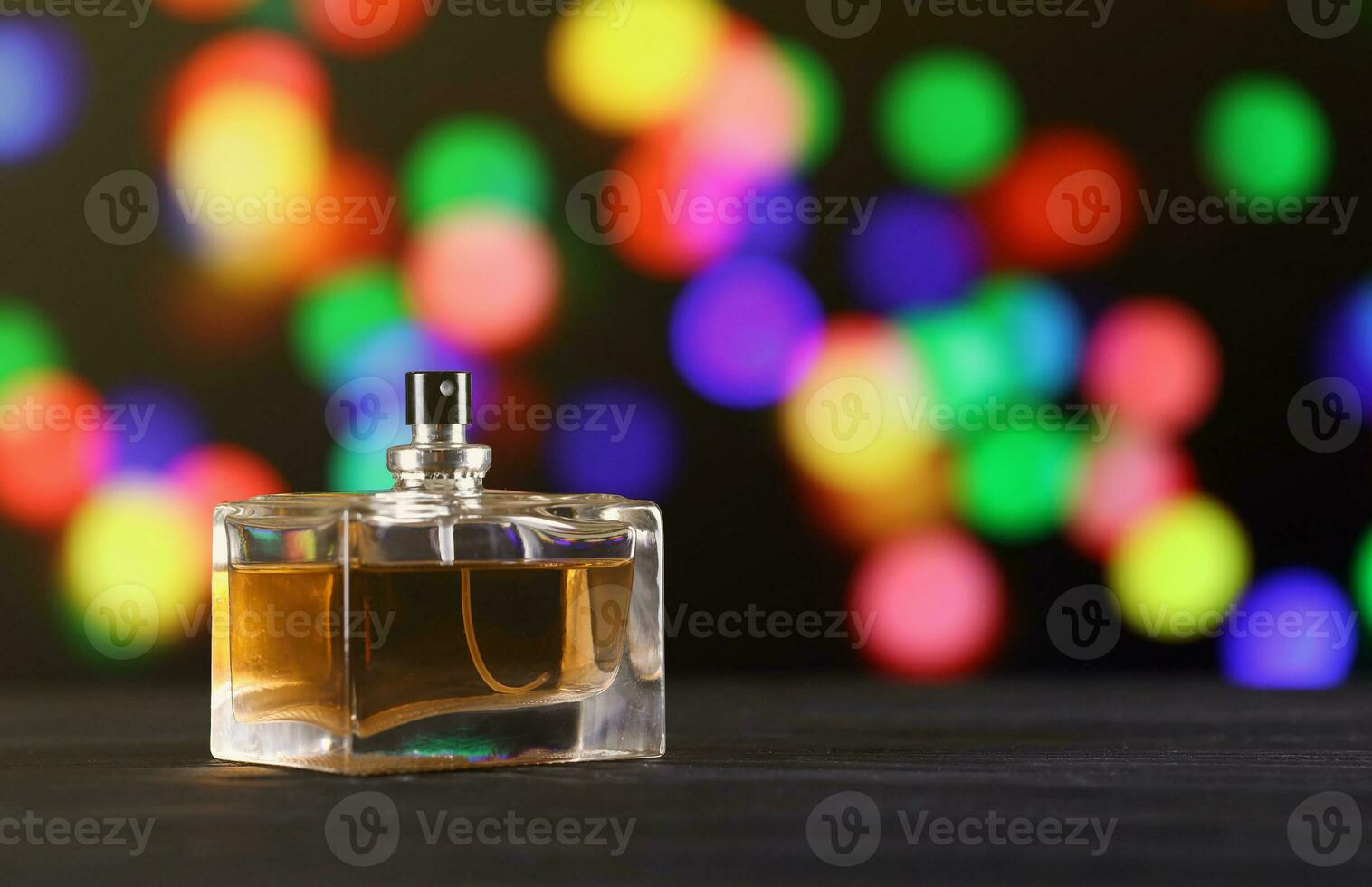 Women fragrance perfume bottle on dark festive background close up. Unnamed blank sprayer bottle of perfume photo