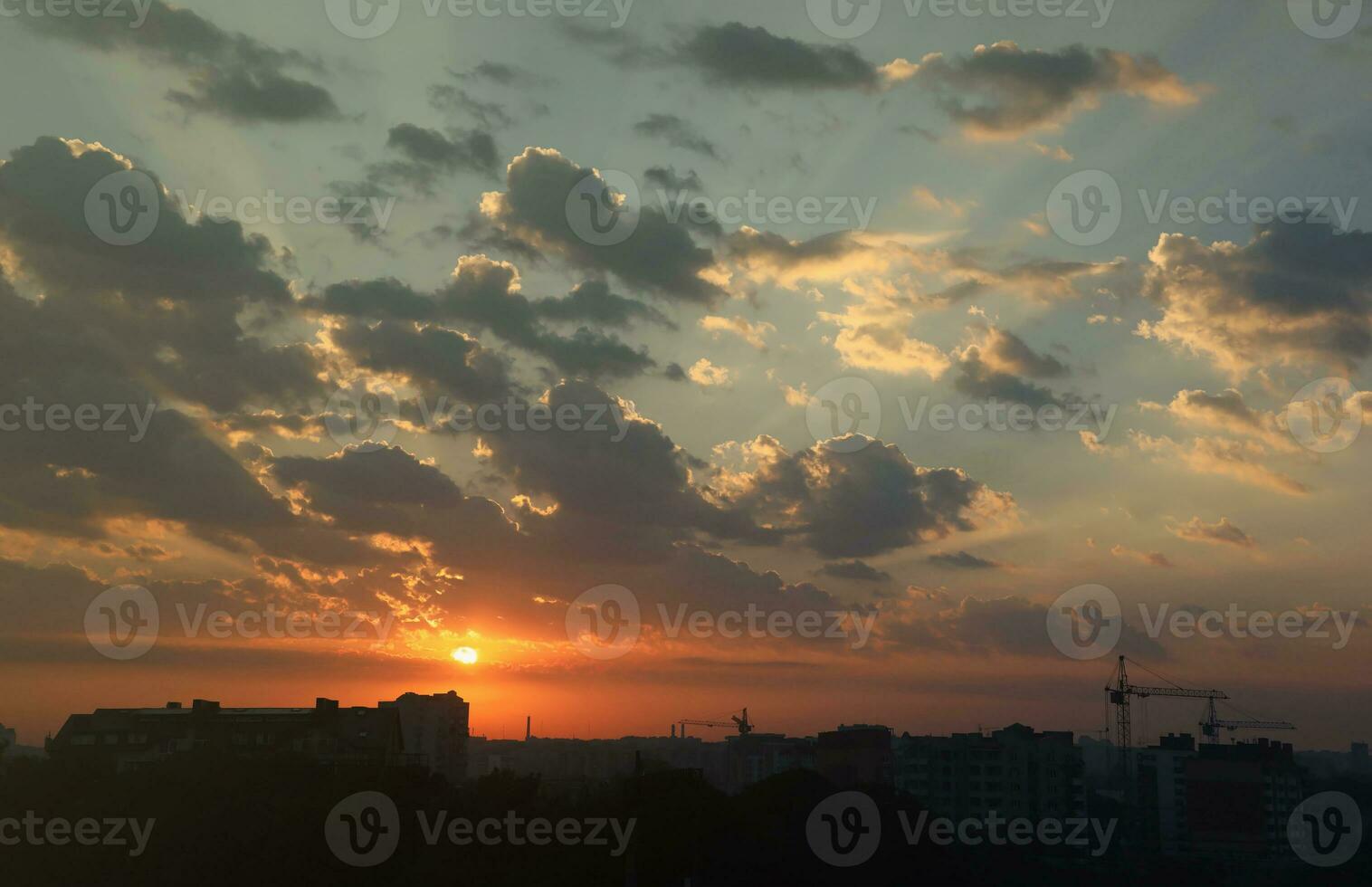 Beautiful sunrise with warm orange sunlight and beams through blue sky photo