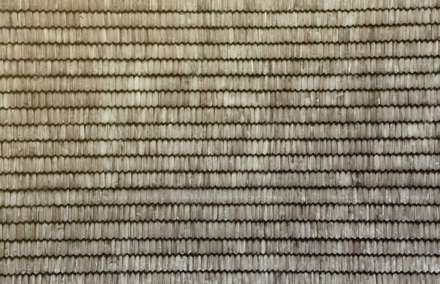 Gray wooden roof tiles background texture. A close up of old gray roof covered with wooden tiles photo