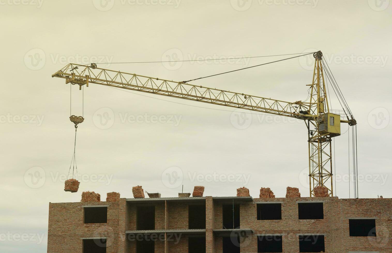 View of a large construction site with buildings under construction and multi-storey residential homes. Tower cranes in action on blue sky background. Housing renovation concept photo