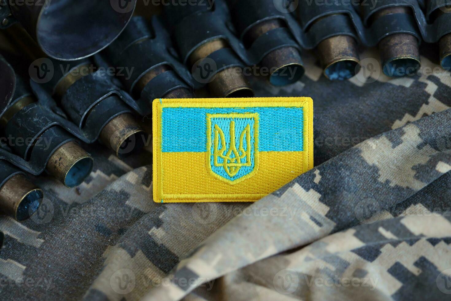 Ukrainian symbol on machine gun belt lies on ukrainian pixeled military camouflage photo