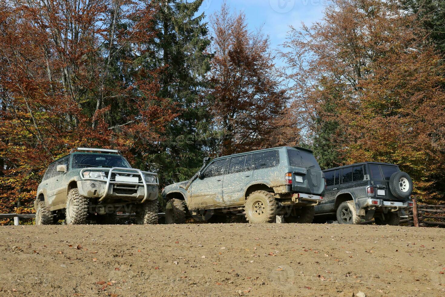Automobile in a countryside landscape with a mud road. Off-road 4x4 suv automobile with ditry body after drive in muddy road photo