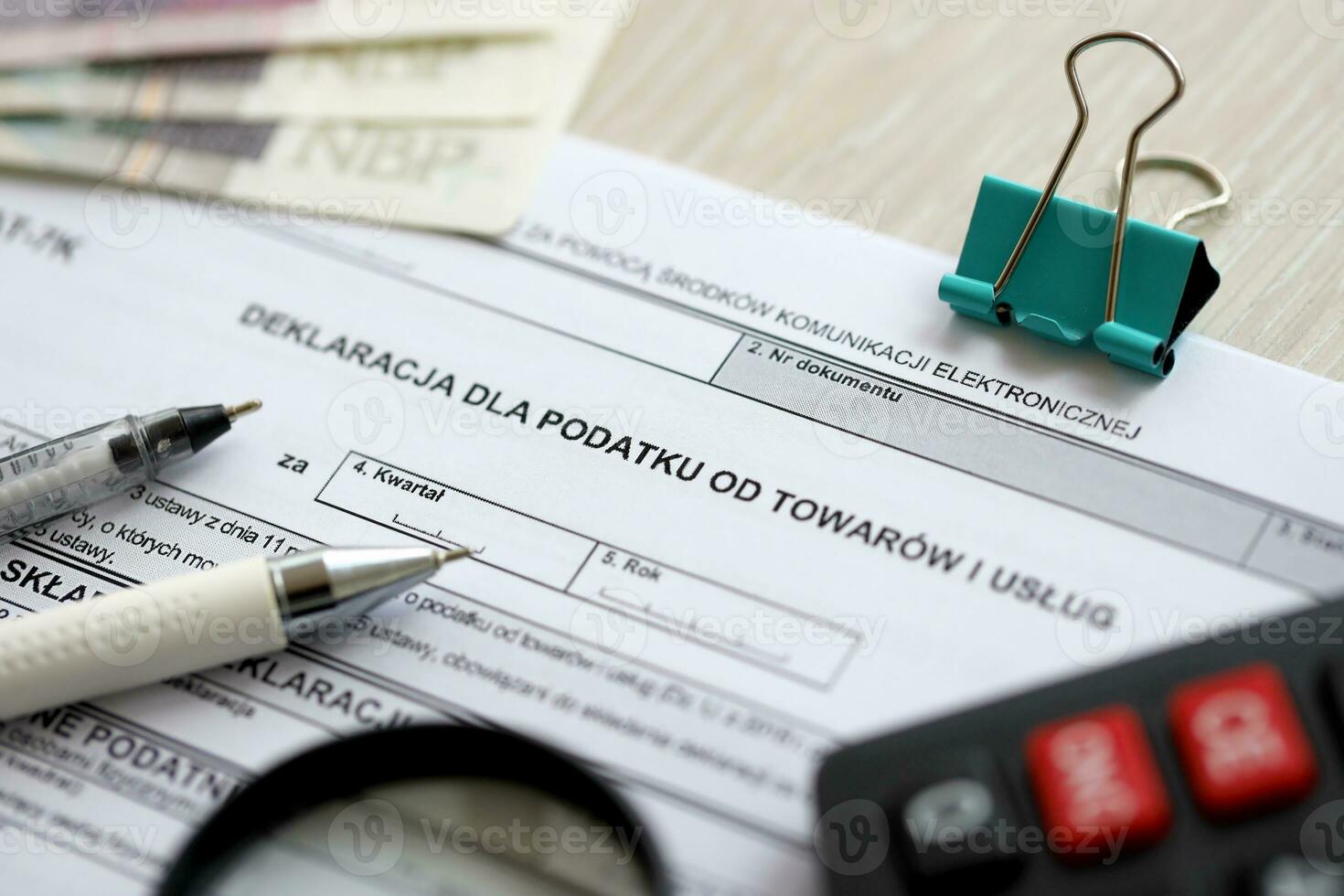 Declaration for tax on goods and services VAT-7K form on accountant table with pen and polish zloty money bills photo