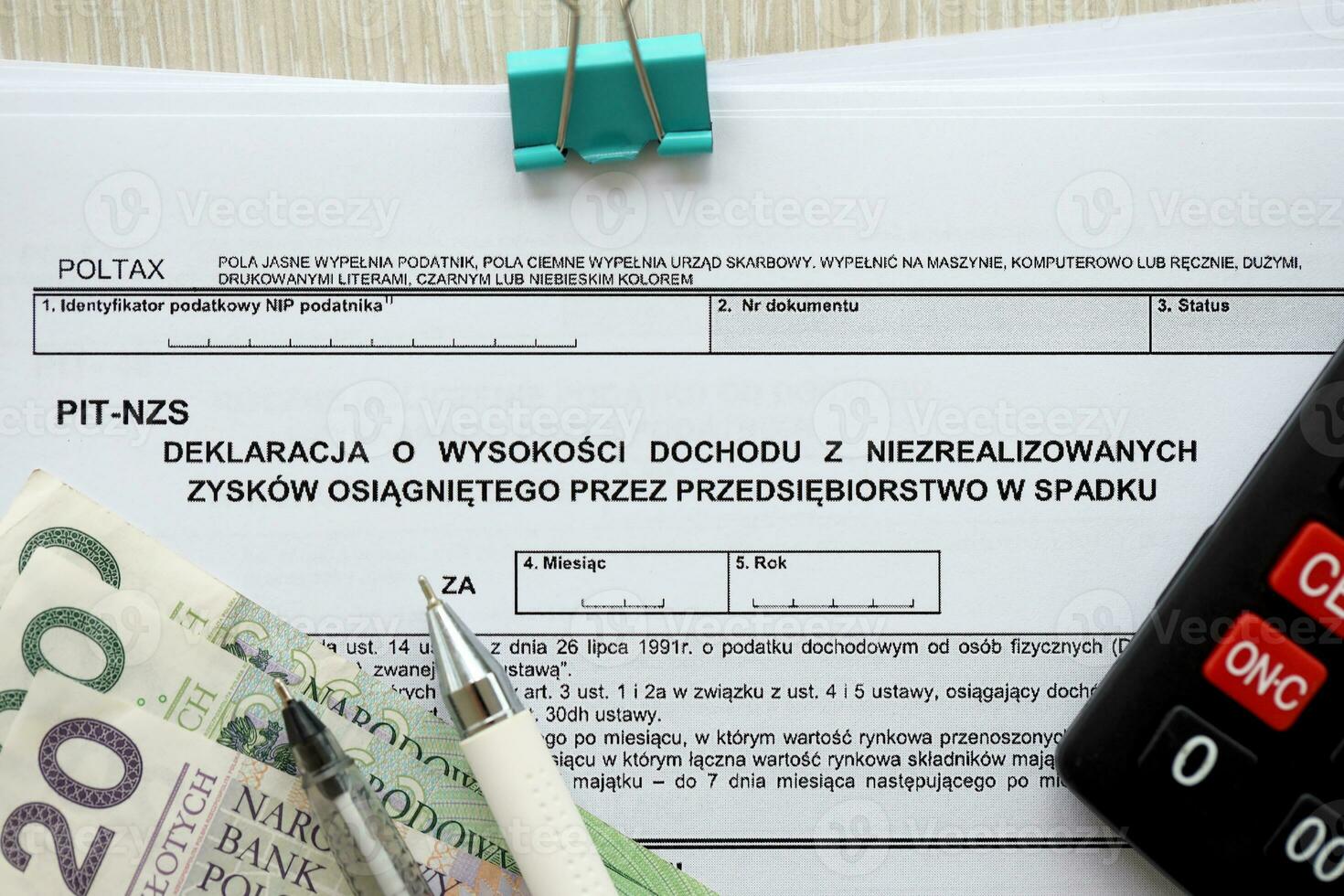 Declaration of income amount from unrealized profits obtained by enterprise as inheritance, PIT-NZS form on accountant table with pen and polish zloty money bills photo