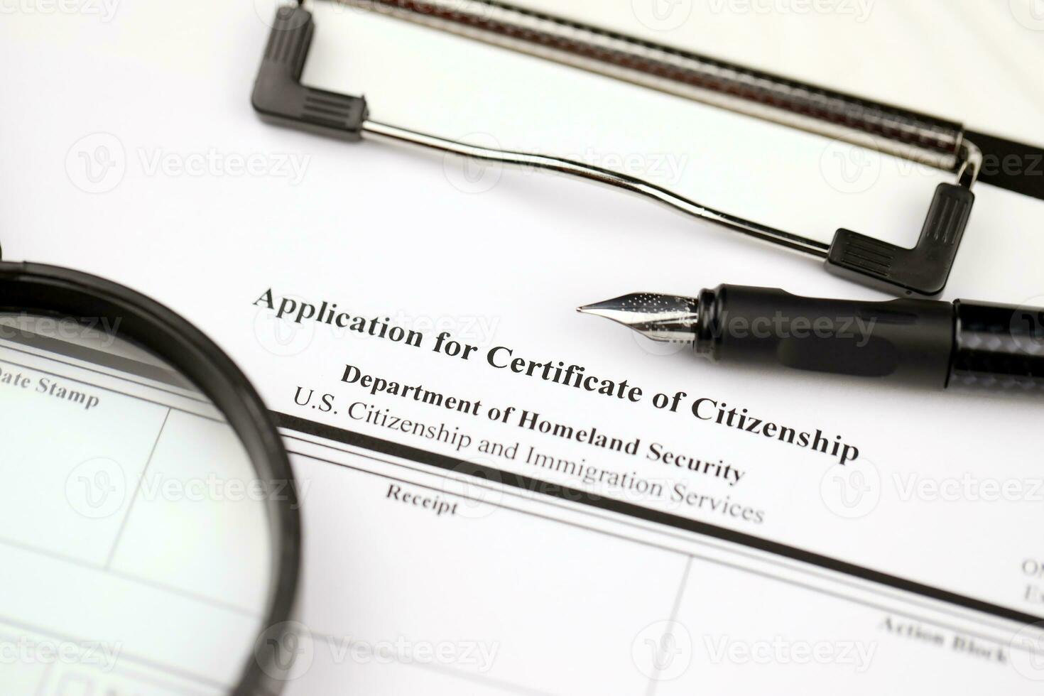 N-600 Application for Certificate of Citizenship blank form on A4 tablet lies on office table with pen and magnifying glass photo