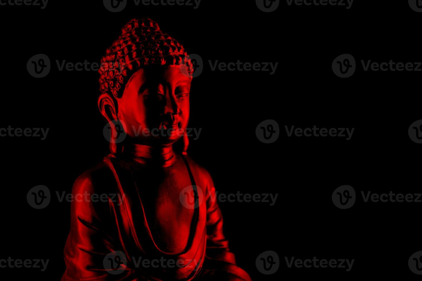 Buda purnima y vesak día concepto, rojo Buda estatua con bajo llave ligero en contra profundo negro antecedentes foto