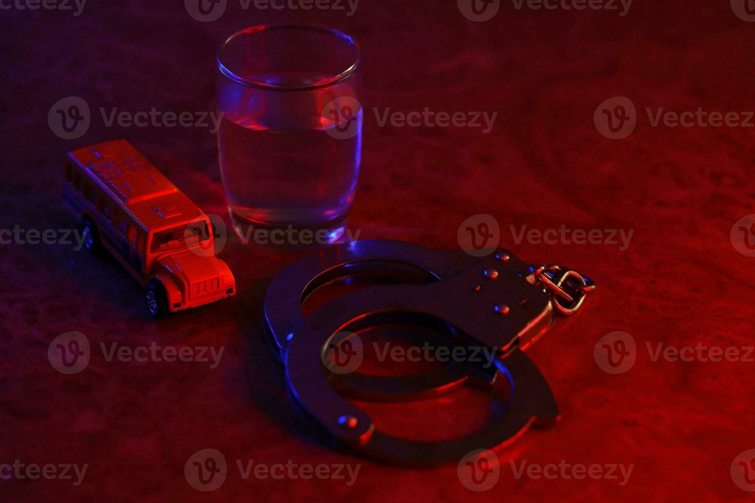 Glass with vodka alcohol drink, knife and handcuffs. Concept of alcoholism, criminal photo