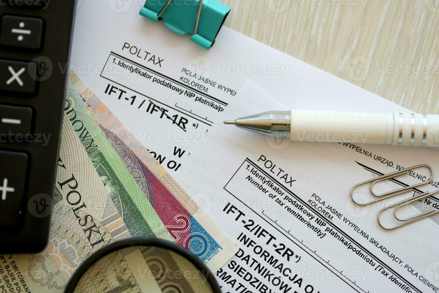 Information on revenue income derived by legal persons and non residents IFT-2, IFT-2R, IFT-1, IFT-1R form on accountant table with pen and polish zloty money bills photo