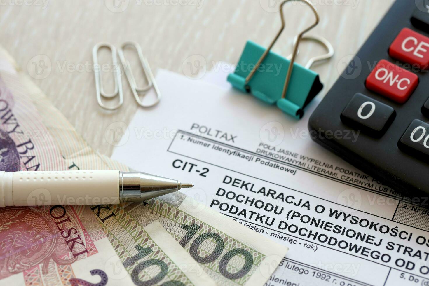 Declaration of the amount of earned income or incurred loss by corporate income tax payer, CIT-2 tax forms on accountant table with pen and polish zloty money bills photo