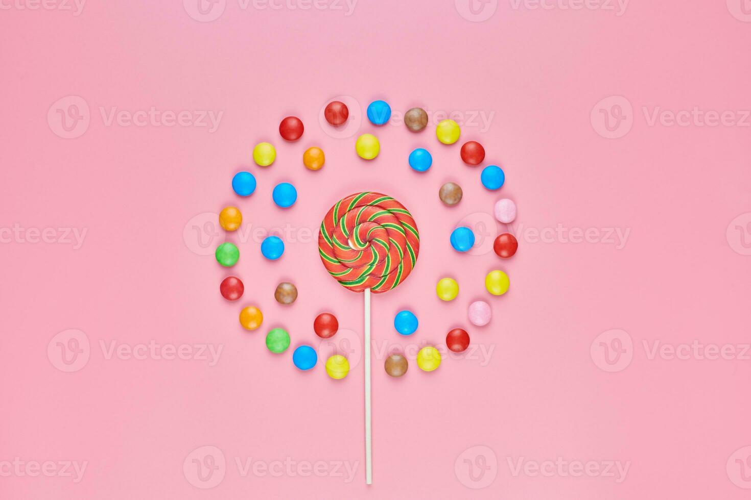 Sweet lollipop and candy on pink background photo