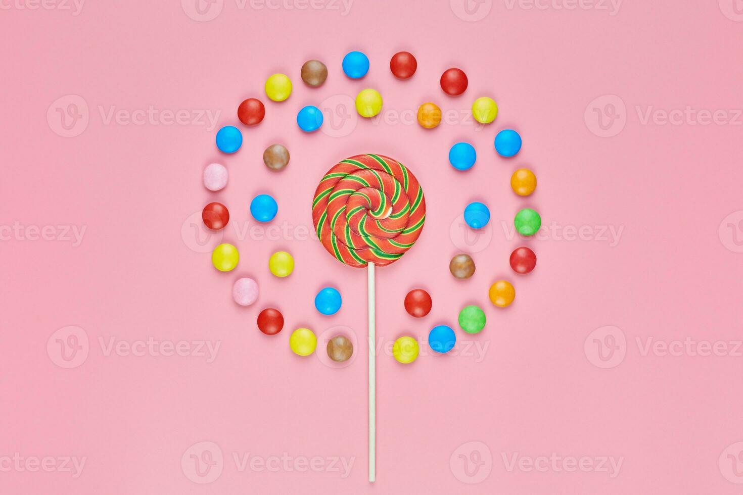 Sweet lollipop and candy on pink background photo