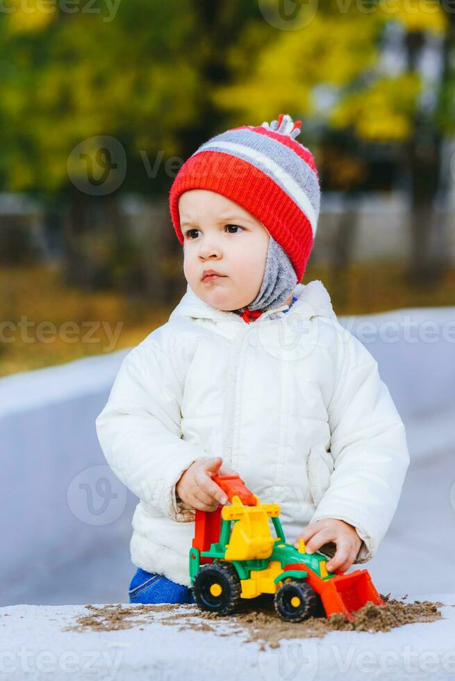 niño jugando excavador en el calle foto