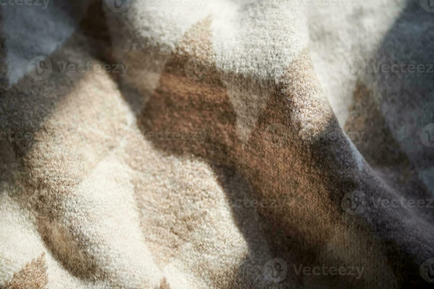 The texture of a warm sweater with a beige pattern. photo