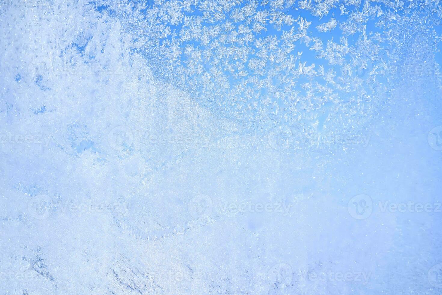 Abstract winter background. Frost on a frozen window against the blue sky. photo
