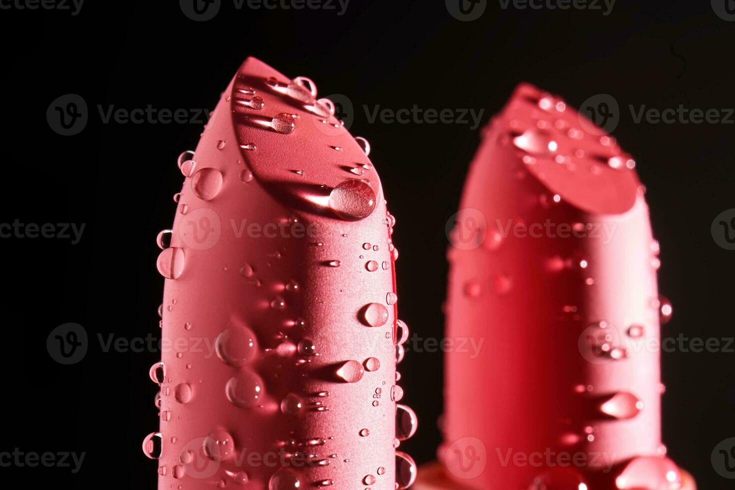 Red lipsticks with water drops on a dark background. photo