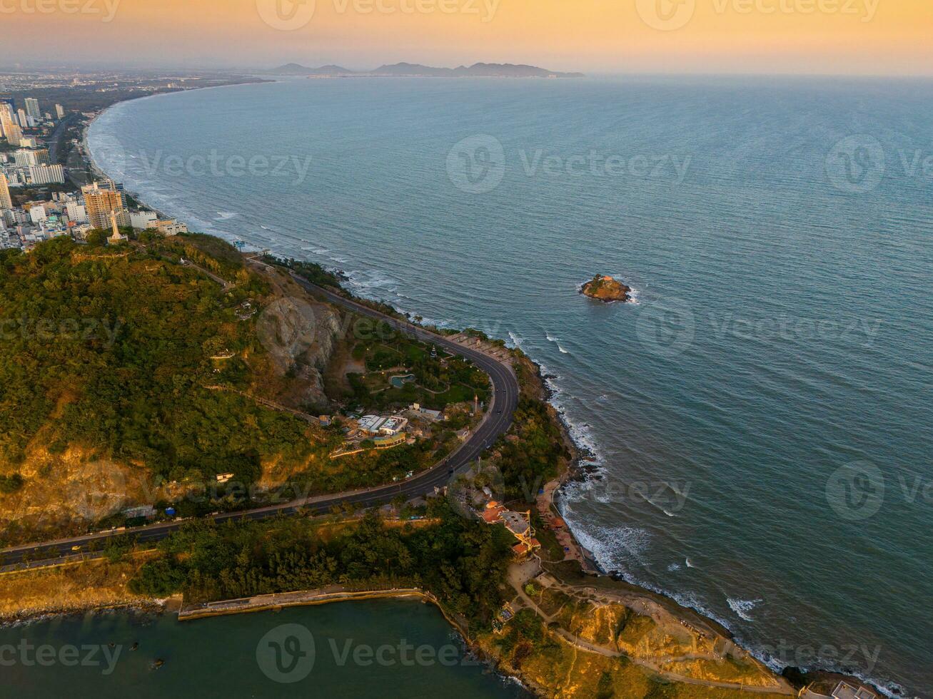 Panoramic coastal Vung Tau view from above, with waves, coastline, streets, coconut trees, Mount Nho in Vietnam behind the statue of Christ the King photo